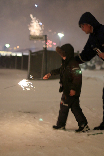 Finnur guiding Bjarki on how to light fireworks.